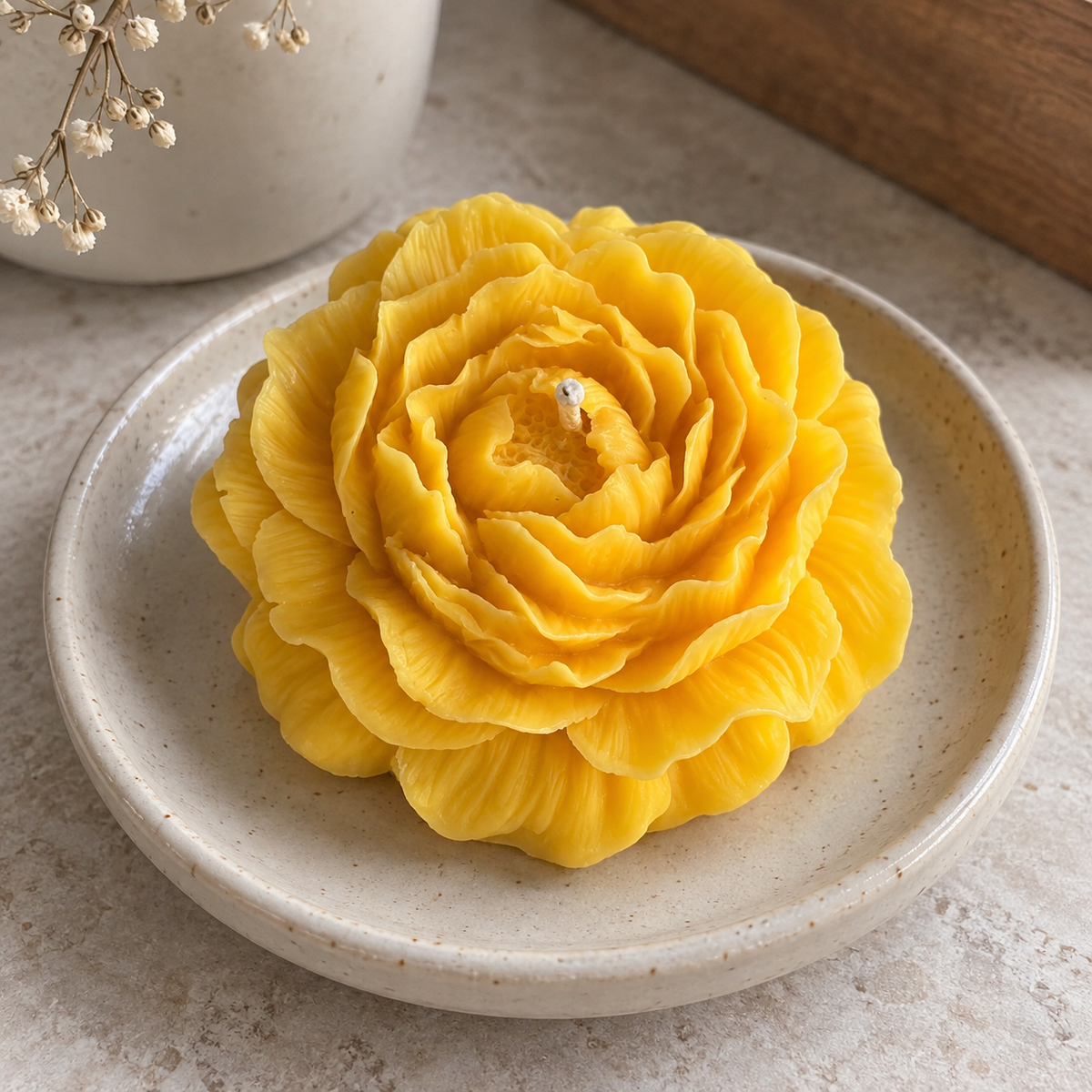 Close-up of Yellow Peony Flower Soy Wax Candle on a ceramic dish with visible wick