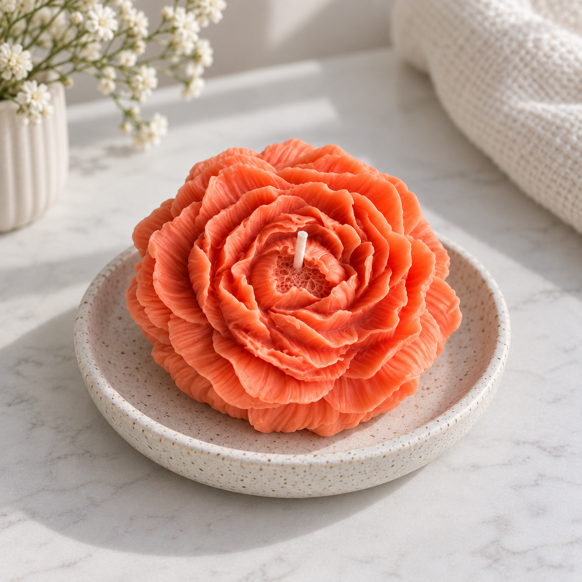 Close-up of Peach Peony Flower Soy Wax Candle on a ceramic dish with visible wick